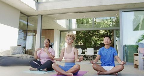 Diverse Group Practicing Meditation in Modern Home Retreat