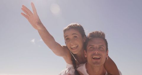 Happy Couple Enjoying Carefree Piggyback Ride Outdoors