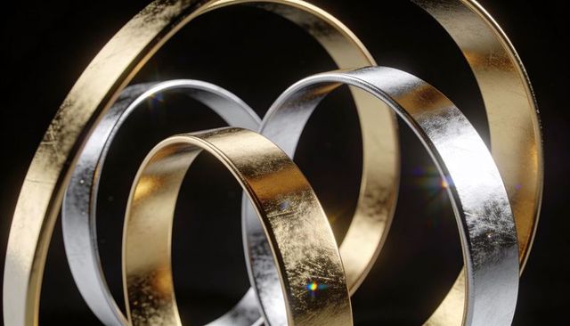 Glinting Interlaced Gold and Silver Rings on Dark Backdrop, Reflective Metallic Abstract Sculpture