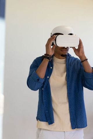African american man adjusting vr headset and safety helmet wearing denim shirt