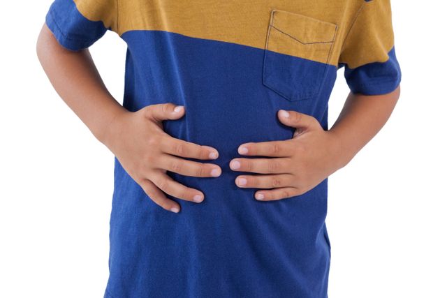 This image shows a child holding his stomach, indicating pain or discomfort. It can be used in healthcare articles, pediatric health blogs, medical websites, or educational materials about children's health and common illnesses. The isolated white background makes it easy to integrate into various designs and layouts.
