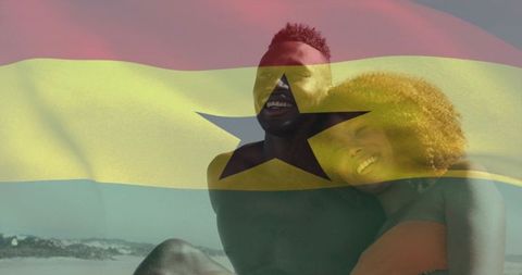 Smiling couple relaxing on sunlit beach with ghana flag overlay for travel, romance, unity