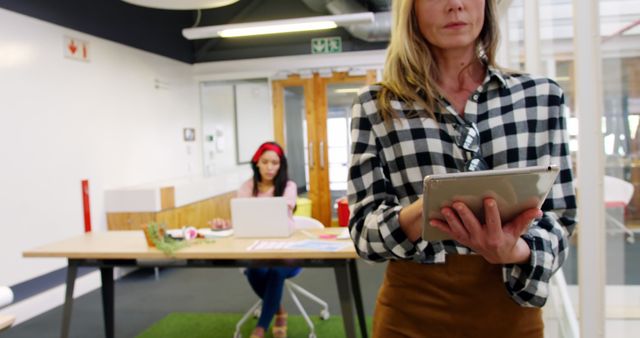 Confident Businesswoman Reviewing Work on Tablet in Modern Office - Download Free Stock Images Pikwizard.com