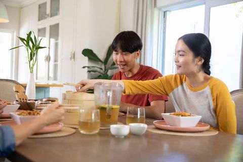Family Enjoying Meal Together Sharing Food at Table