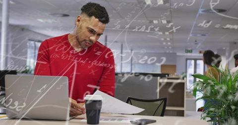 Focused man reviewing charts in modern office workspace