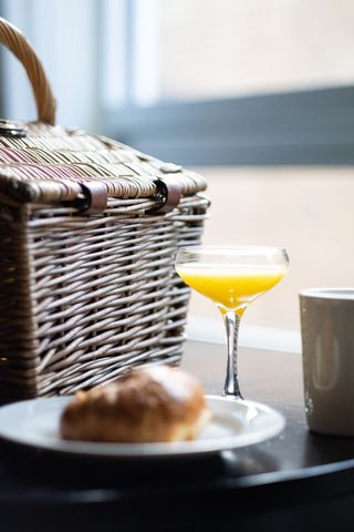 Elegant Brunch Scene with Pastry, Orange Juice, and Basket