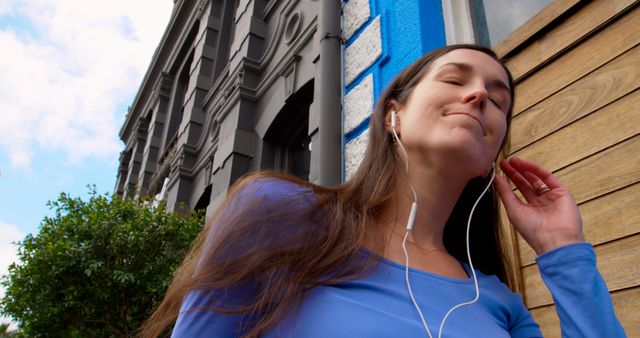 Content Young Woman Enjoying Music with Earphones Outdoors - Download Free Stock Images Pikwizard.com