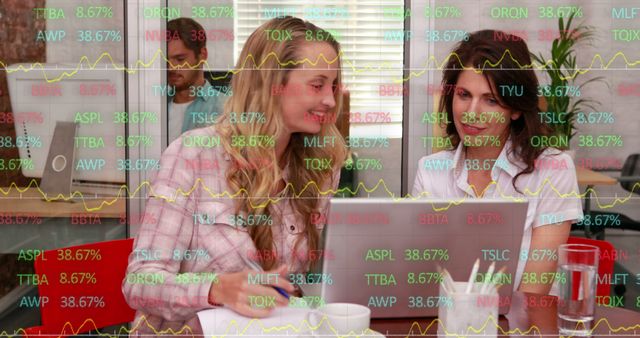 Image of stock market data processing over two caucasian women discussing at office. Global economy and business technology concept