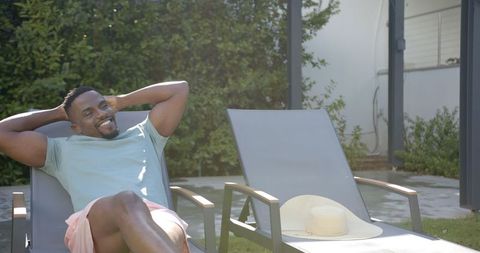 Man Relaxing on Lounge Chair in Sunny Backyard - Download Free Stock Images Pikwizard.com