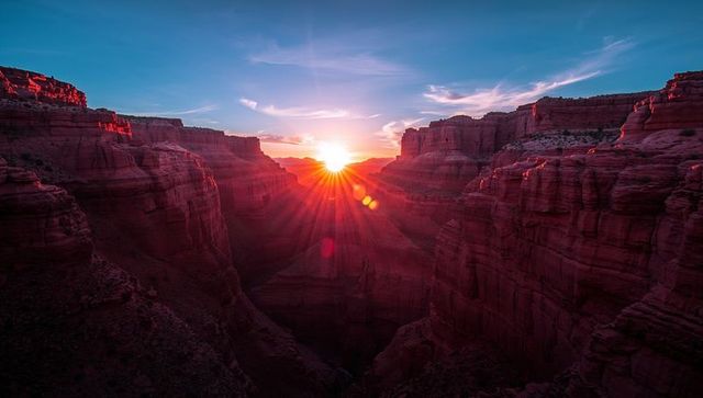 Enchanting sunburst over dramatic sandstone canyons in desert dawn