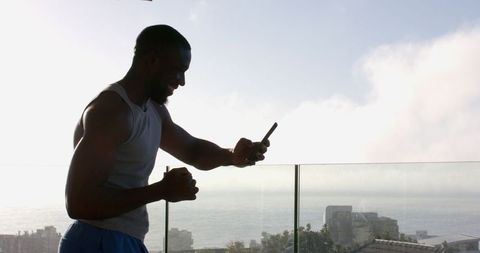Man Celebrating Achievement on Balcony with Serene Ocean View