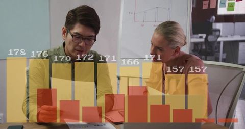 Colleagues analyzing sales performance with bar chart overlay in modern meeting room