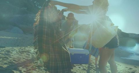 Friends gathering around cooler on sunlit beach cove with plaid overshirt and coastal vibe