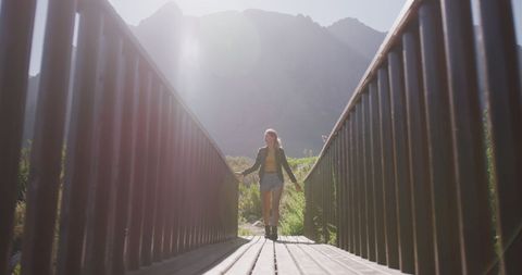 Woman Hiking Across Wooden Bridge in Mountain Sunlight - Download Free Stock Images Pikwizard.com