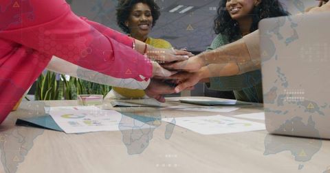 Diverse team showing unity with hands together in modern office