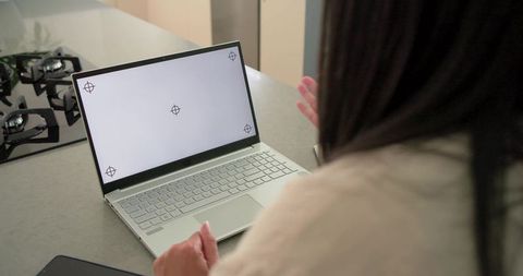 Mature professional woman conducting virtual consultation from modern kitchen workspace