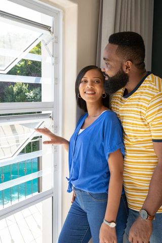 Couple Enjoying Scenic View Through Stylish Louvered Window