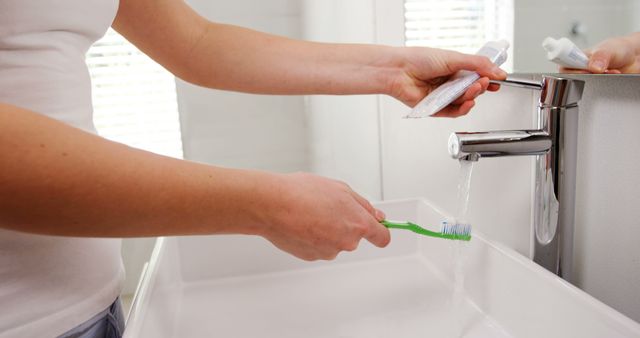 Mid section of woman washing toothbrush under sink in bathroom at home 4k