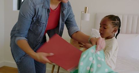Mother and Daughter Carefully Packing Backpack Together