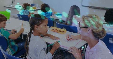 Teacher leaning and guiding braided girl writing at classroom desk with yellow pencil box