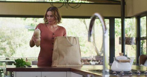 Pregnant Woman Unpacking Groceries in Modern Kitchen