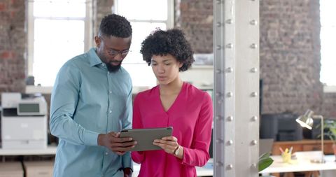 Business Colleagues Collaborating with Tablet in Modern Office Space