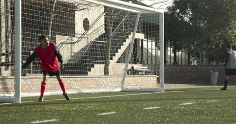 Young goalkeeper preparing for soccer match on sunny day