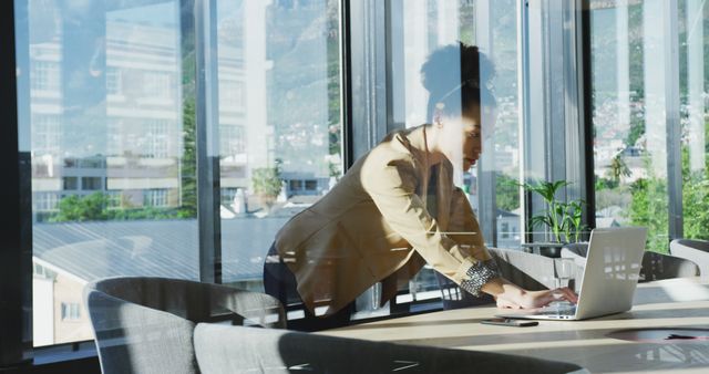 Young Woman Working on Laptop in Modern Office with Large Windows - Download Free Stock Images Pikwizard.com