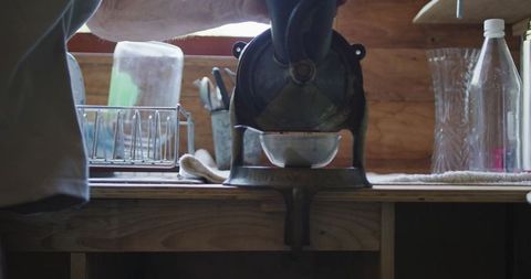 Caucasian senior grinding coffee beans in rustic kitchen