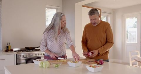 Senior Couple Preparing Fresh Vegetables in Home Kitchen