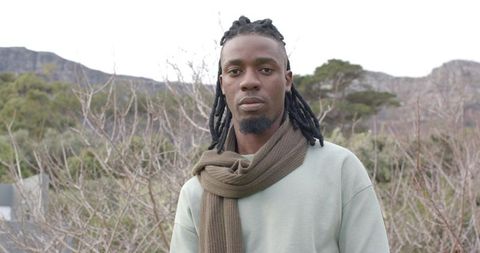Portrait of African American man wearing scarf in winter mountain landscape