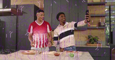 Friends taking selfie while making homemade pizza on kitchen island in modern home