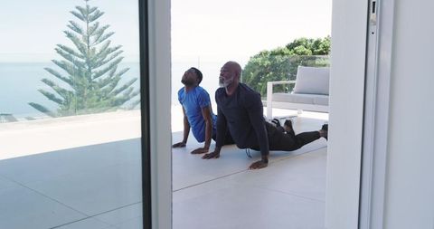 Father and Son Enjoy Yoga on Hypnotic Oceanfront Deck