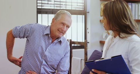 Senior Man Consulting Healthcare Professional for Back Pain Relief