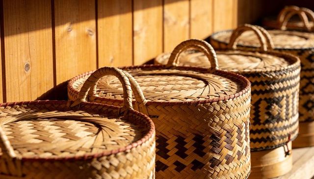 Sunlit woven lidded bamboo baskets with loop handles, geometric patterns for home decor