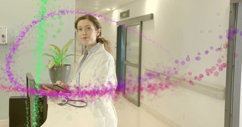 Female doctor using tablet at hospital desk with digital health graphics