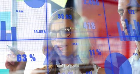 Business professionals analyzing interactive transparent analytics dashboard with stylus