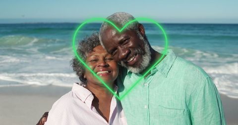 Senior Couple Embracing on Beach with Heart Overlay, Celebrating Love and Togetherness