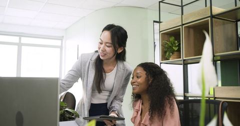 Diverse female coworkers collaborating in modern workspace