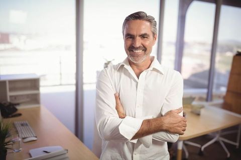 Confident Mature Businessman Standing in Modern Office