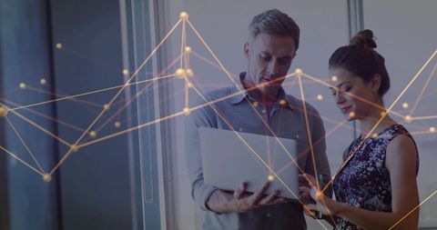 Professionals collaborating on network analytics with laptop and gold visualization overlay