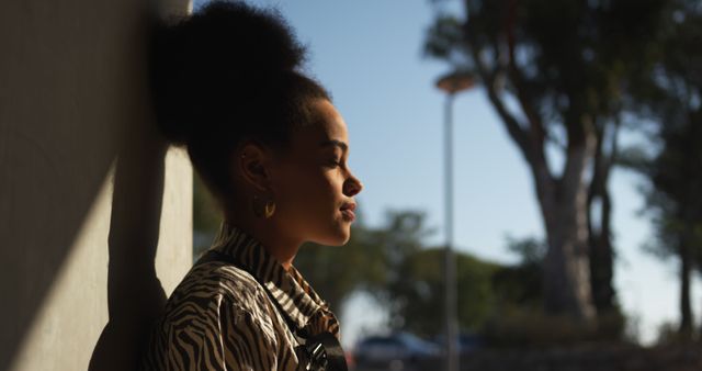 Pensive Woman Leaning Against Wall in Sunny Outdoor Setting - Download Free Stock Images Pikwizard.com