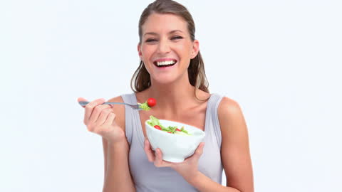 Smiling Woman Enjoying Fresh Salad in Bright Setting