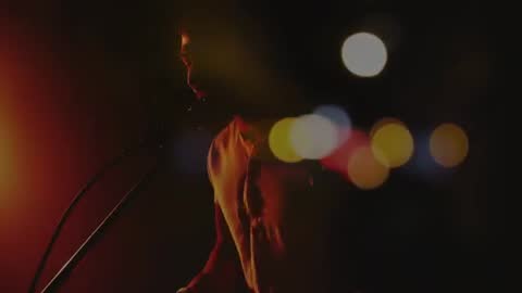Musician Singing into Microphone during Atmospheric Live Performance