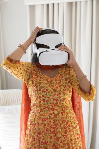 Indian Woman Wearing VR Headset in Bedroom Setting