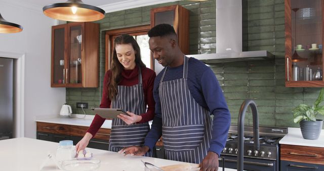 Couple Baking Together in Modern Kitchen, Wearing Striped Aprons - Download Free Stock Images Pikwizard.com