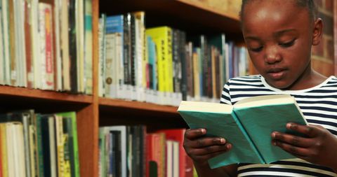 Young Girl Immersed in Book in Library