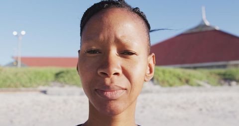 Woman Practicing Yoga on Beach with Calm Expression