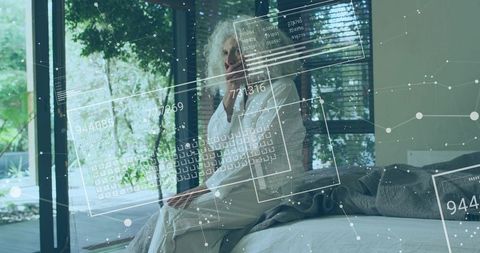 Senior Woman Sitting on Bed in Modern Glass Bedroom Touching Chin with AR Health HUD