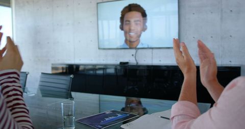 Colleagues Applauding During Video Conference in Modern Office